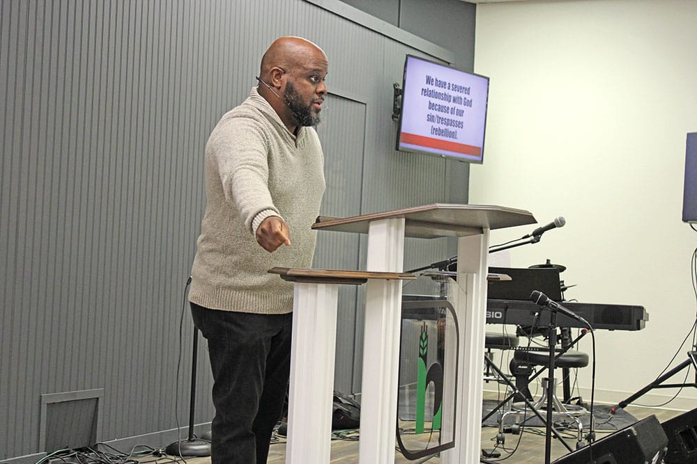 Ed Johnson III stands preaches at the pulpit