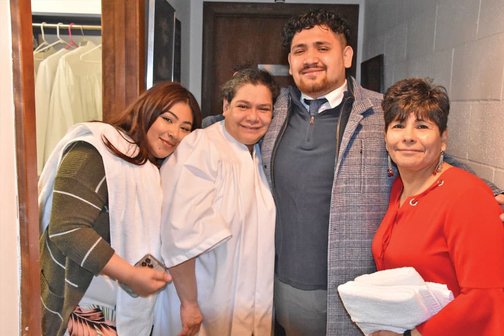 A woman named Mary Ann (pictured second from left) smiles after being baptized at the church. She is seen with members of her family. SUBMITTED PHOTOS